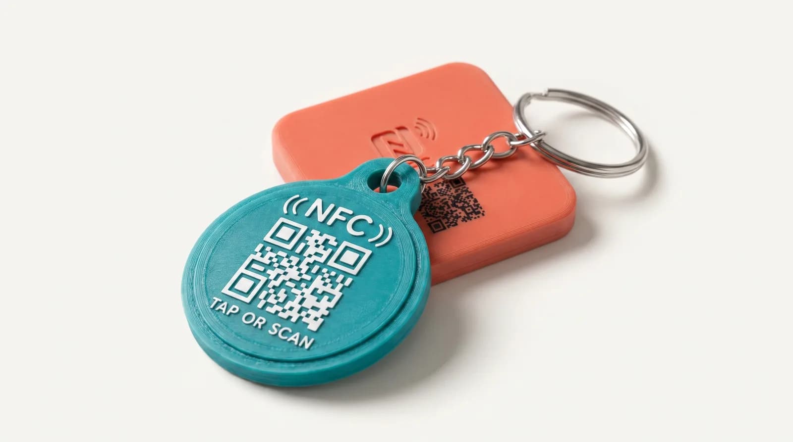 3D-printed Tapora NFC keychain and badge with NFC and QR code, shown together on a clean studio surface